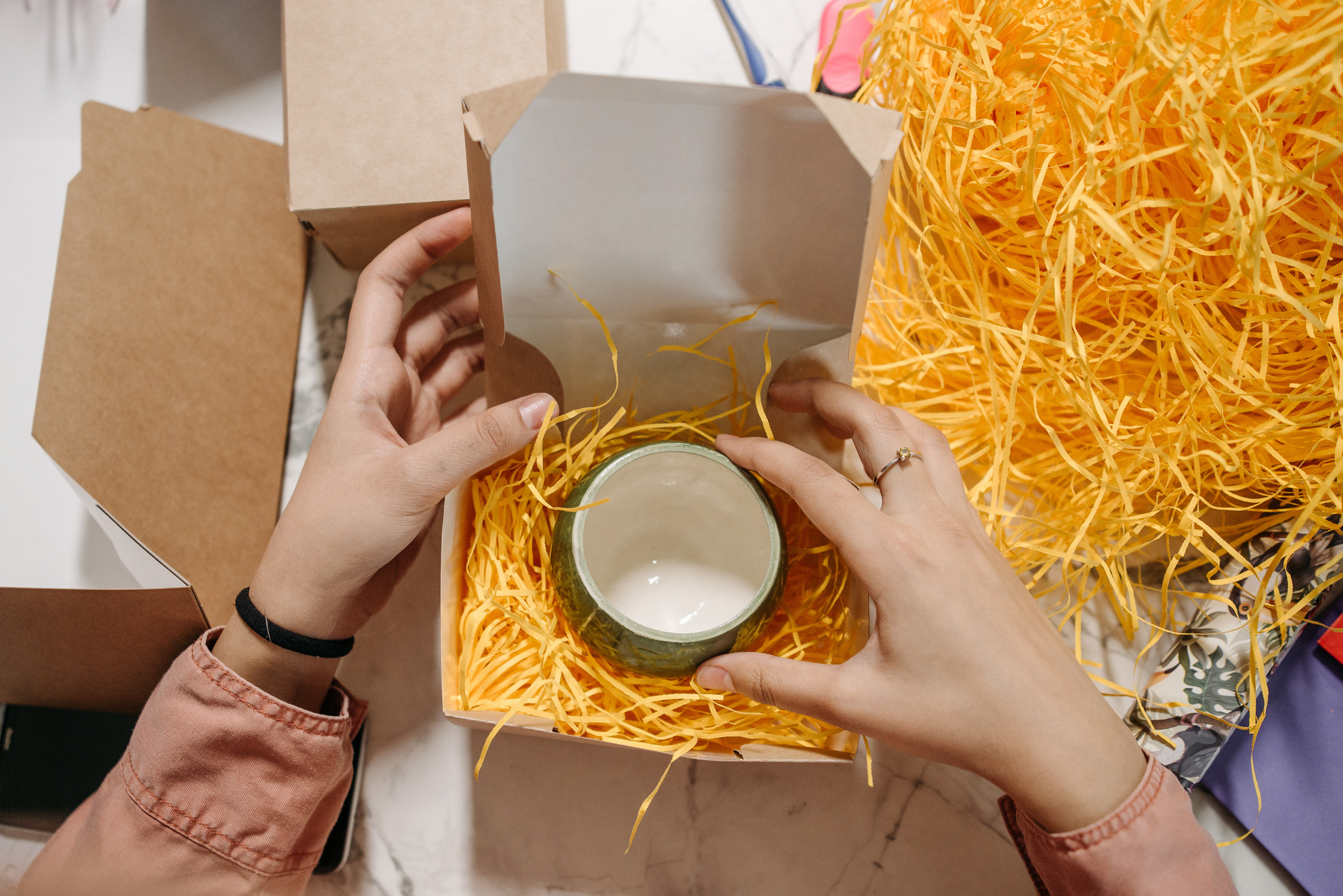 A Person Packing Ceramic Cup in a Cardboard Box